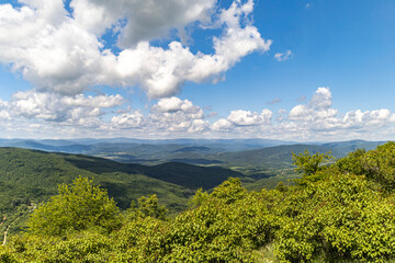 A mountain landscape in a sunny day with small white clouds