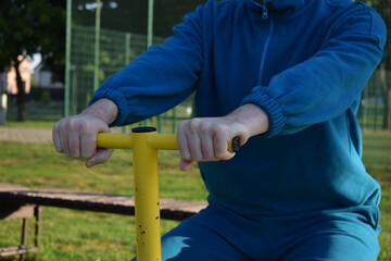 A dedicated young athlete puts in the hard work, vigorously training on gym equipment outdoors to...