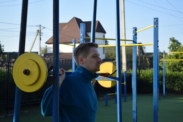 A dedicated young athlete puts in the hard work, vigorously training on gym equipment outdoors to...