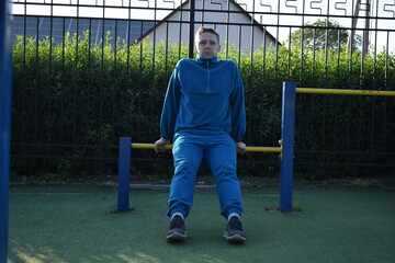 A dedicated young athlete puts in the hard work, vigorously training on gym equipment outdoors to...