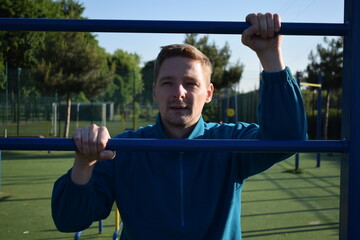 A dedicated young athlete puts in the hard work, vigorously training on gym equipment outdoors to...
