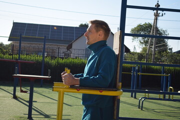 A dedicated young athlete puts in the hard work, vigorously training on gym equipment outdoors to...