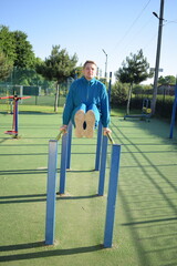 A dedicated young athlete puts in the hard work, vigorously training on gym equipment outdoors to...