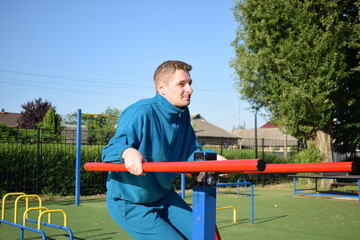 A dedicated young athlete puts in the hard work, vigorously training on gym equipment outdoors to...