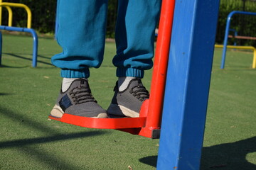 A dedicated young athlete puts in the hard work, vigorously training on gym equipment outdoors to...