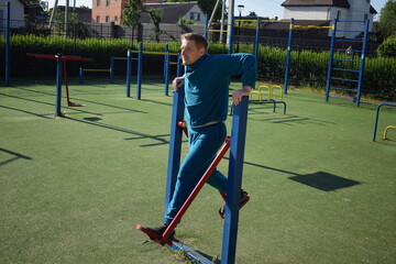 A dedicated young athlete puts in the hard work, vigorously training on gym equipment outdoors to...