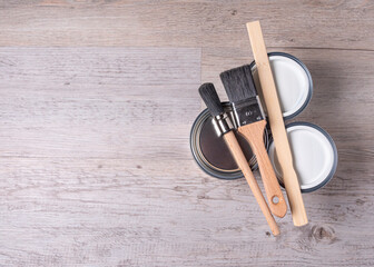 House renovation, paint cans and brushes on a wooden background with copy space
