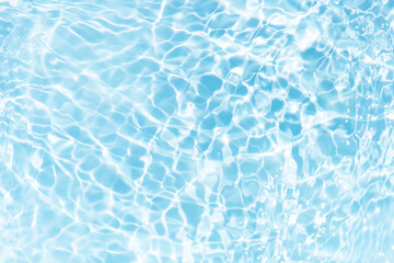 Blue water with ripples on the surface. Defocus blurred transparent blue colored clear calm water surface texture with splashes and bubbles. Water waves with shining pattern texture background.