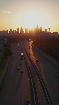 Dallas skyline at sunrise with highway traffic as camera flies straight up- 9x16 vertical 