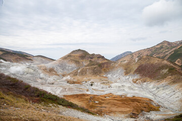 Obraz premium 百名山の立山、荒涼とした地獄谷と秋の紅葉が美しい風景