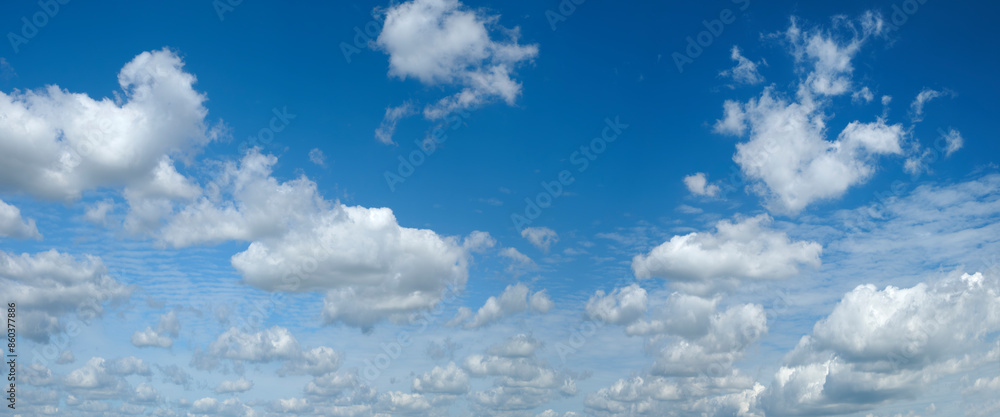 Poster the sky is blue and filled with clouds. the clouds are scattered throughout the sky, with some close