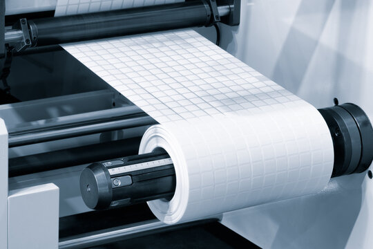 A roll of white paper is passed through the machine. printer and sticker machine, which is used for printing and applying stickers packaging or industrial products. Concept precision and efficiency