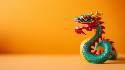 Obraz premium chinese dragon figurine on orange background - traditional symbol of good luck and fortune.