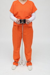 weibliche Strafgefangene in Handschellen und Fusschellen und orangen Overall mit Sicherungskasten
