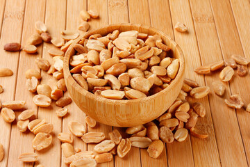 Roasted peeled peanuts in wooden bowl on table