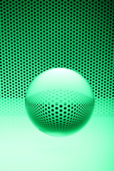 Glaskugel mit grünem Gitter und Lochstruktur mit grünem Lochblech als Hintergrund