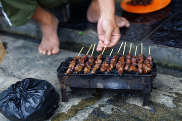 The proses of burning savory beef satay on the burning coals. Indonesian famous street food.