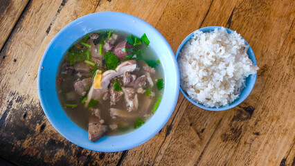 Breakfast soup with blue bowl on wooden table