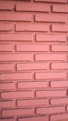 The wall is made of orange bricks.