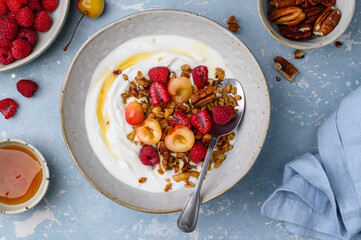 Healthy breakfast. Bowl with Greek yogurt, granola, raspberries, cherries and nuts. Healthy eating...