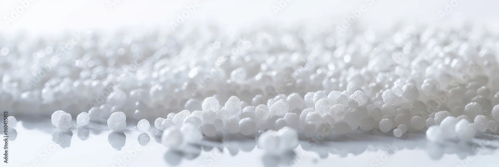 Poster a macro photograph showcasing white plastic granules scattered on a smooth surface, creating a minim