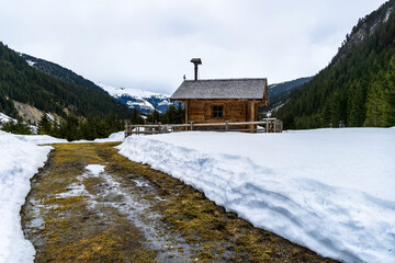 Wooden chapel in the mountains in winter with lots of snow. A cottage in the Austrian Alps.