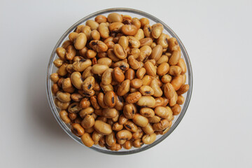 Fried soy bean on transparent glass bowl, isolated on white background, flat lay or top view