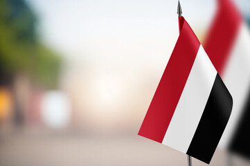 Small flags of Yemen on a blurred background