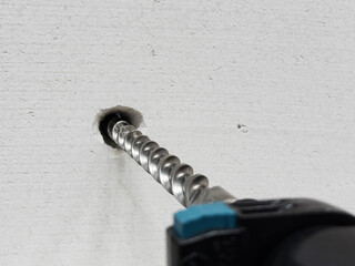 Work of a jackhammer. Drilling hole in concrete wall.