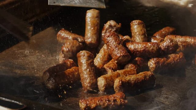 Grilled Balkan Cevapi Sizzling on Hot Grill Pan in Slow Motion