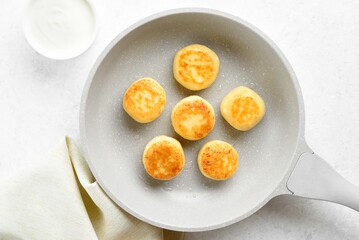 Cottage cheese pancakes (syrniki or curd fritters) in skillet