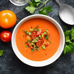 Delicious gazpacho soup in bowl over blue stone background