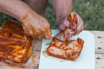 Barbecue at the cottage. May holidays. Barbecue in nature. The process of cooking meat on the grill, close-up. Barbecue of pork ribs on the grill.