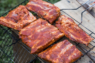 Barbecue at the cottage. May holidays. Barbecue in nature. The process of cooking meat on the grill, close-up. Barbecue of pork ribs on the grill.