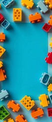 Obraz premium Colorful plastic building blocks arranged around a blue background.