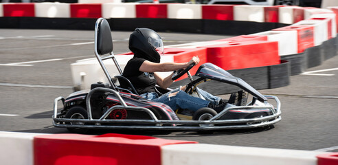 Girl In Protective Helmet Driving Go-Kart By Extreme Racing Track