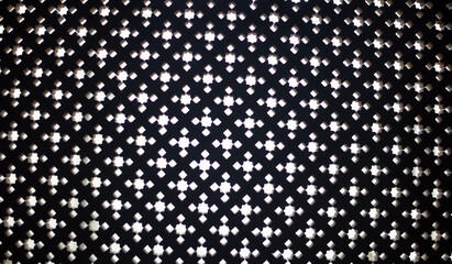 A pattern of white light crosses against a black background, creating a geometric design.