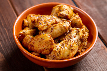chicken stewed in spices in a clay bowl on the table