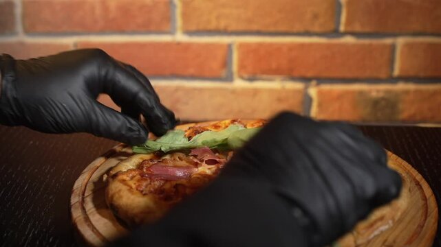 chef prepara una pizza en un restaurante con guantes negros