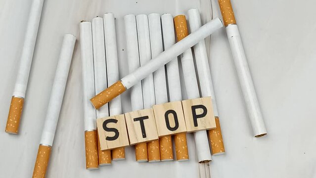 tas de cigarettes, vue du dessus, avec le mot Stop &eacute;crit en lettres en bois dessus.
