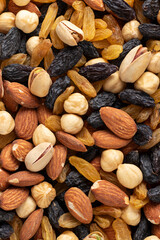 Mix of almonds, pistachios, hazelnuts, golden and black raisins. Top view.