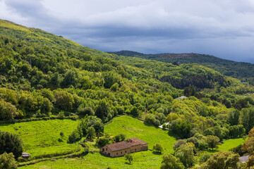 Landscape of green mountains with trees and cloudy sky in the Bejar area, Salamanca, Spain.