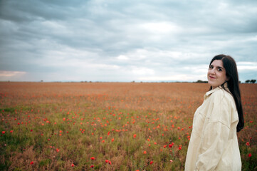 A girl enjoys the poppy field at sunset