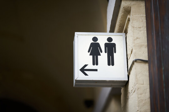 beleuchtetes Hinweisschild f&uuml;r eine Toilette f&uuml;r M&auml;nner und Frauen in der Altstadt von Br&uuml;gge in Belgien