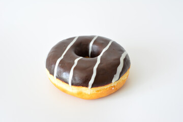 a chocolate donut with white and brown stripes isolated