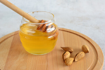 a glass jar of honey with a wooden stick next to it  