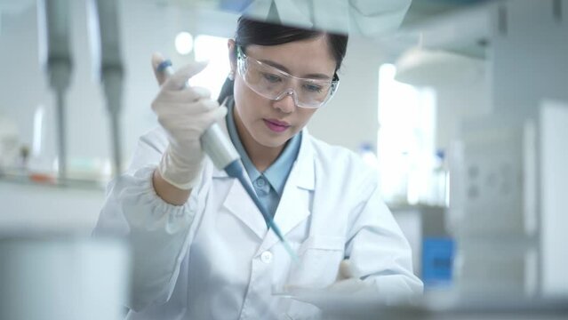 woman doctor using pipette in lab