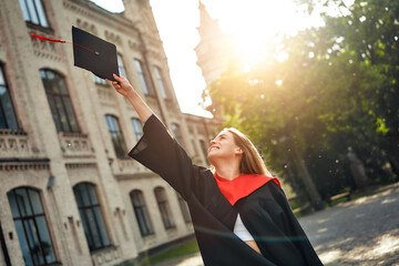 Fototapeta premium Young Graduate Celebrating Academic Achievement and Success at University Campus