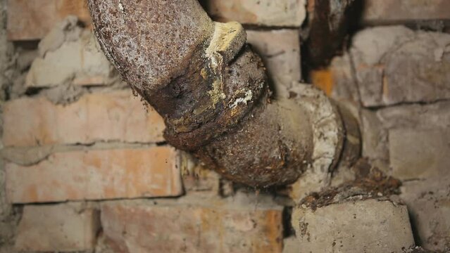 Old rusty leaking cast iron sewer pipe in the basement. Looping infinite.