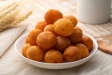 Thai Deep Fried Sweet Potato Balls in white plate. (Khanom khai nok kratha)